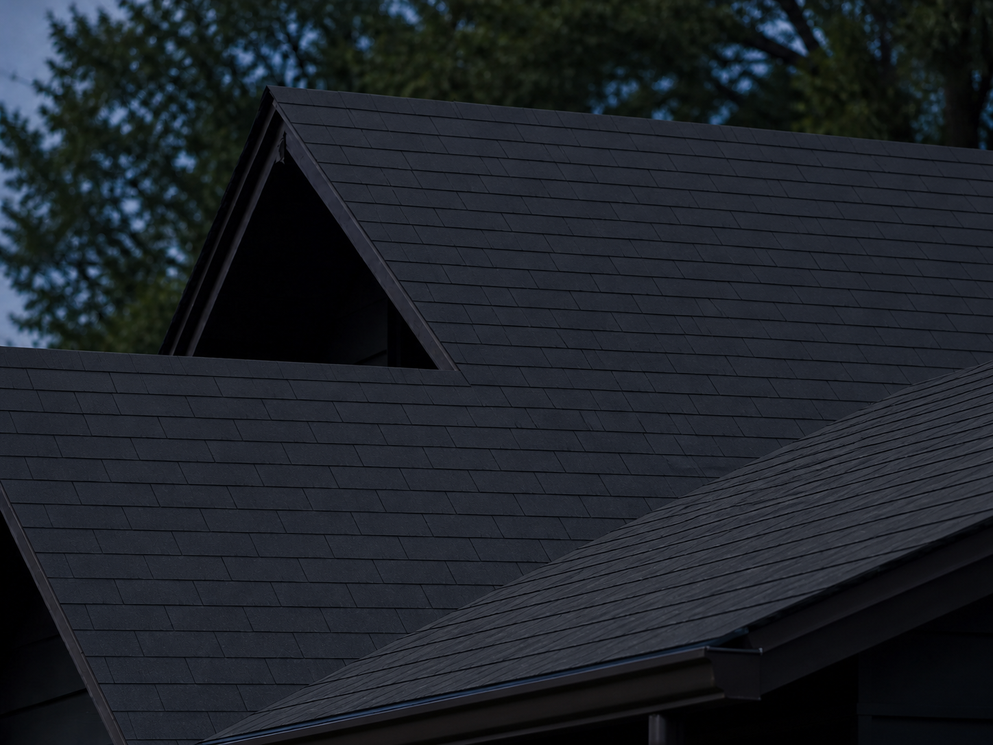 Charcoal roof with flat single-layer three-tab shingles in an alternating half-tab pattern