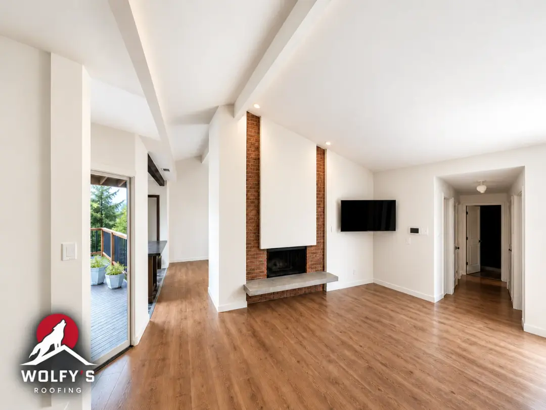 Bright living room with wood flooring, a brick fireplace, and access to a deck